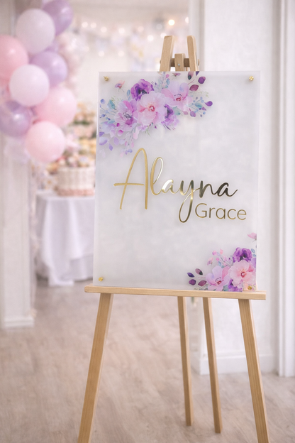 Personalized baby shower welcome sign on frosted acrylic with gold name lettering and pink purple floral design, 20x28 nursery decor sign on easel