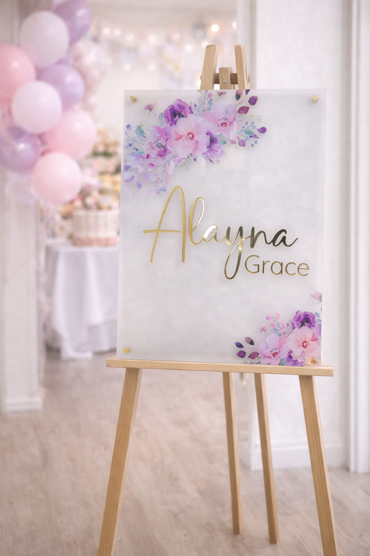 Personalized baby shower welcome sign on frosted acrylic with gold name lettering and pink purple floral design, 20x28 nursery decor sign on easel